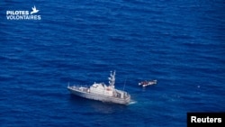 A Libyan coast guard vessel is pictured next to a migrant craft at sea, near Libya, June 5, 2019. A wooden boat carrying at least 22 African migrants was intercepted June 7 north of the Bouri offshore oil field, around 105 kilometers (65 miles) from Tripo