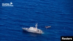 Kapal Garda Pantai Libya berlayar di samping kapal migran di laut, dekat Libya, 5 Juni 2019. 