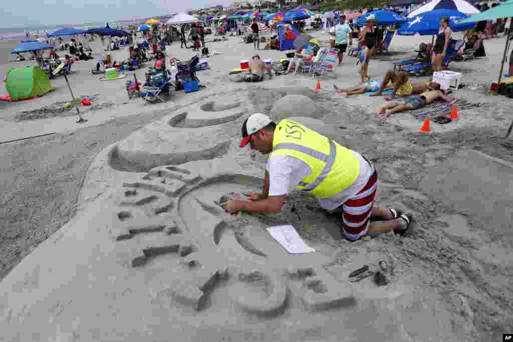 David Burt, with team LS3P and architectural firm out of Charleston, S.C., makes the official eclipse sand castle logo in preparation for the solar eclipse Monday, Aug. 21, 2017, on the beach at Isle of Palms, S.C. The city of Isle of Palms hosted a beach party &quot;Get Eclipsed on IOP&quot;. (AP Photo/Mic Smith)