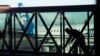 FILE - A worker cleans a jet bridge at Paine Field in Everett, Wash., before passengers board an Alaska Airlines flight on March 4, 2019. Seattle-based Alaska Airlines owns Horizon Air.