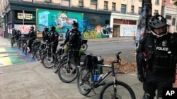 Cảnh sát đi xe đạp làm thành rào cản tại East Pike và Đại lộ 12, trong thành phố Seattle, cho phép nhân viên thành phố dẹp lều trại của người biểu tình ngày 1/7/2020..