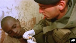 Un médecin français soigne un enfant tutsi dans le camp militaire de Bisesero, le 2 juillet 1994. (AP Photo/Jean Marc Bouju)