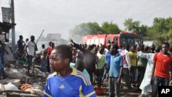 People gather at the scene of a car bomb explosion, at the central market, in Maiduguri, Nigeria, July 1, 2014. 