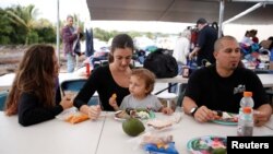 FILE - Members of a family with two children eat a meal in Pahoa, Hawaii, May 7, 2018.