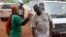 FILE - A health worker uses a thermometer to screen a man at a makeshift road block run by Guinean security forces outside the town of Forecariah, Guinea.