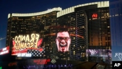 An advertisement for Mexican entertainer Franco Escamilla is reflected in a window along the Las Vegas Strip, Sept. 14, 2017, in Las Vegas. Mexican Independence Day will be celebrated this weekend, and Las Vegas will roll out the red, white and green carpet to celebrate "El Grito."