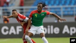 Bakary Koné du Burkina Faso, à droite, dans un duel avec Emilio Nsue de la Guinée équatoriale, à gauche, au cours de la Coupe d’Afrique des nations à Bata, Guinée équatoriale, 21 janvier 2015.