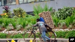 In this photo taken Thursday, March 26, 2020 a man transports cartons of eggs on the back of a bicycle due to restrictions on movement attempting to halt the spread of the new coronavirus, in Kigali, Rwanda.