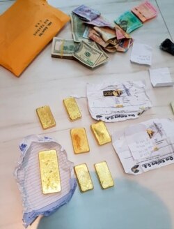 En esta foto proporcionada por la Policía Federal de Brasil, se muestran barras de oro incautadas y efectivo después de una redada en una operación que presuntamente contrabandeó ilegalmente decenas de millones de dólares, el 6 de diciembre de 2019.