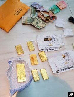 En esta foto proporcionada por la Policía Federal de Brasil, se muestran barras de oro incautadas y efectivo después de una redada en una operación que presuntamente contrabandeó ilegalmente decenas de millones de dólares, el 6 de diciembre de 2019.