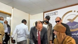 FILE - Seif al-Islam, right, the son and one-time heir apparent of late Libyan dictator Moammar Gadhafi registers his candidacy for the country's presidential elections in Sabha, Libya, Nov. 14, 2021.
