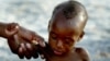 FILE - A mother holds on to her emaciated infant at an emergency feeding clinic in Maradi, Niger.