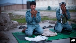 Afghan policemen pray at a checkpoint outside of Jalalabad, east of Kabul, in this March 18, 2013, file photo. 
