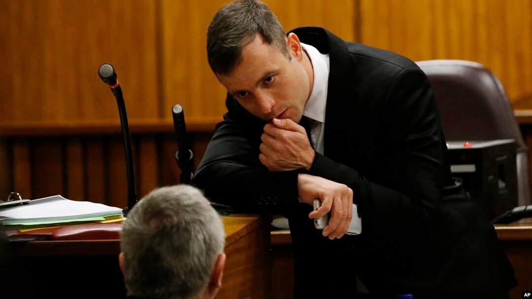 Oscar Pistorius berbicara dengan pengacaranya di sela sidang pengadilan di Pretoria, Afrika Selatan (16/10).