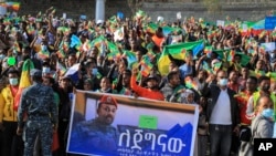 FILE: People gather behind a placard showing Prime Minister Abiy Ahmed at a rally organized by local authorities to show support for the Ethiopian National Defense Force (ENDF), at Meskel square in Addis Ababa, Ethiopia, Nov. 7, 2021.