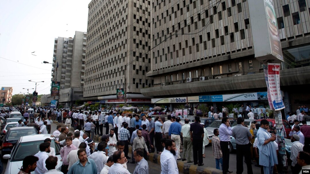 Warga di kota Karachi, Pakistan keluar dari gedung setelah gempa yang berpusat di Iran terasa di Karachi (16/4). 