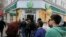 FILE - People stand in a line as they wait to enter a branch of Sberbank of Russia bank in the Crimean city of Simferopol April 7, 2014.