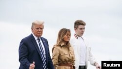El presidente Donald Trump, la primera dama, Melania Trump, y el hijo de ambos, Barron Trump, al fondo, se disponen a embarcar en el Air Force One, el pasado 16 de agosto.