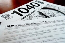 FILE - Forms printed from the Internal Revenue Service website that are used for 2018 U.S. federal tax returns are seen in Zelienople, Pennsylvania, Feb. 13, 2019.
