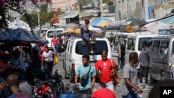 Pedestrians and commuters fill a street in Port-au-Prince, Haiti, Tuesday, March 12, 2024