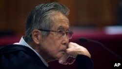 FILE - Peru's former president Alberto Fujimori, photographed through a glass window, attends his trial at a police base on the outskirts of Lima, Peru, June 28, 2016.