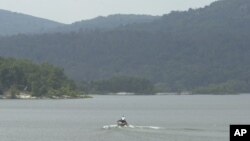 Un barco patrulla el río Wanaque en Nueva Jersey. Uno de los niños sufrió un colapso pulmonar y el otro chico tiene una lesión en la columna, pero se encuentran fuera de peligro, según informes de la policía.