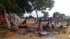 FILE - Residents displaced from a surge of violent attacks squat on blankets and in hastily made tents in the village of Masteri in west Darfur, Sudan, July 30, 2020. 