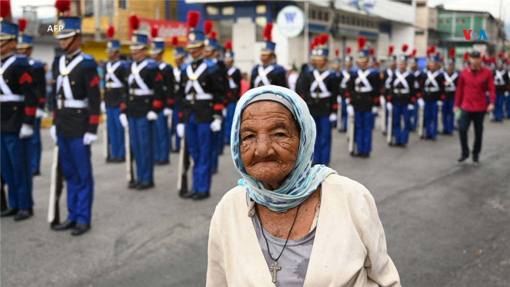 Una persona mayor pasa frente a los cadetes militares de la academia General Francisco Morazán, mientras participan en el desfile militar como parte de la celebración de la independencia de Honduras en Tegucigalpa.