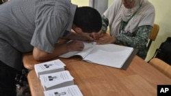 A voter prepares to cast his ballot inside a polling station during the presidential election in Algiers, Algeria, Sept. 7, 2024.