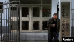 Seniman pembangkang Tiongkok, Ai Weiwei menanti keputusan persidangan di luar gedung pengadilan DIstrik Chaoyang (Foto: dok). Pengadilan ini bulan lalu mengemukakan adanya para pejabat di kota Changge, propinsi Henan, Tiongkok tengah, yang mempekerjakan orang-orang untuk mencegat para pelapor pelanggaran. Para pencegat ini telah dijatuhi hukuman penjara oleh pengadilan Beijing, atas tuduhan penahanan ilegal.