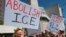 Manifestantes portan carteles durante un acto frente a la oficina del Servicio de Inmigración y Aduanas, ICE, en Los Ángeles, California, el lunes, 2 de julio de 2018.