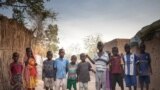 FILE - Sudanese refugees children pose for photographs in the Treguine camp, in Hadjer Hadid, in the Ouaddaï region of eastern Chad, on March 24, 2019.