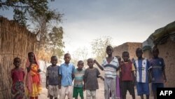 FILE - Sudanese refugees children pose for photographs in the Treguine camp, in Hadjer Hadid, in the Ouaddaï region of eastern Chad, on March 24, 2019.