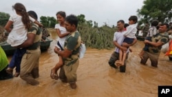 FILE - India army soldiers carry children rescued from flood affected villages near Thara in Banaskantha district, Gujarat, India, July 26, 2017.