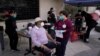 Wilbert Swaringer, a 71-year-old pastor who volunteers as a life coach for homeless people in downtown Los Angeles's Skid Row, talks to registered nurse Julie Hurtado before getting his COVID-19 vaccine in the courtyard of the Midnight Mission in…