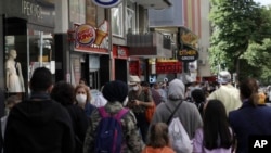 FILE - People walk along Tunali Hilmi Street, in Ankara, Turkey, June 3, 2020, days after the government lifted a series of restrictions imposed to fight the coronavirus pandemic. 