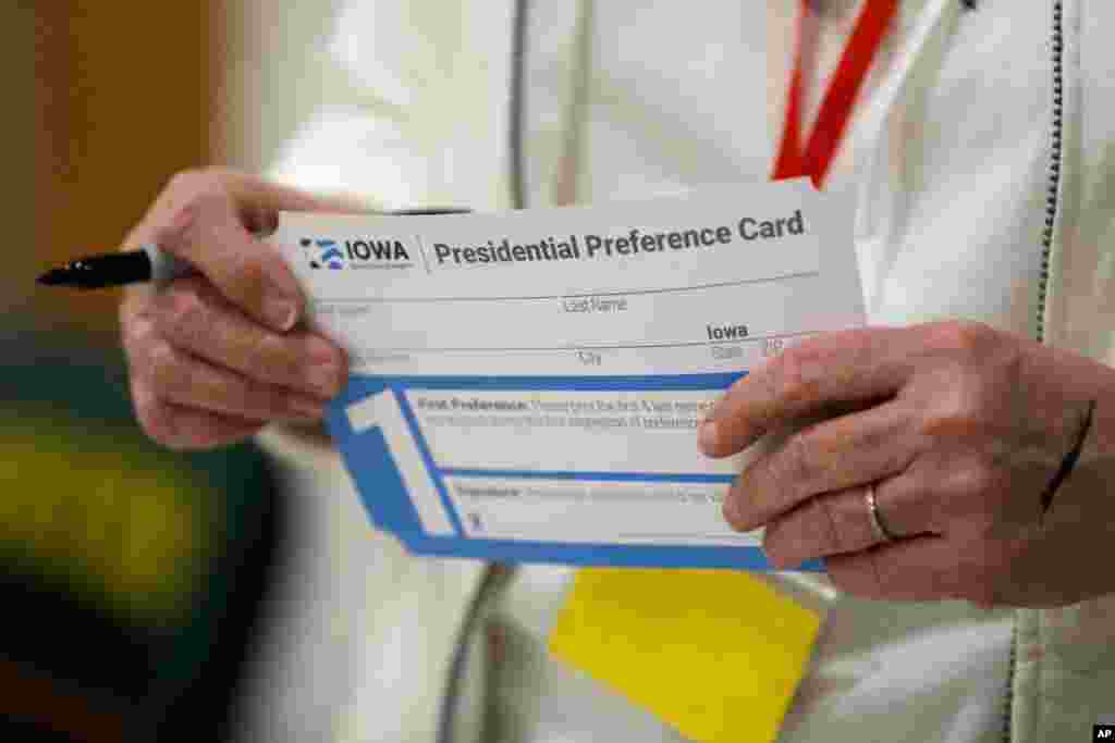 A volunteer holds a presidential preference card before the start of a Democratic caucus at Hoover High School, Feb. 3, 2020, in Des Moines, Iowa. 