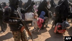 Perempuan dan anak-anak dievakuasi dari wilayah pertahanan kelompok militan ISIS di Baghuz tiba di daerah pemeriksaan yang dikuasai oleh Pasukan Demokratik Suriah yang didukung AS di Deir el-Zour, provinsi di sebelah timur Suriah, 6 Maret 2019.
