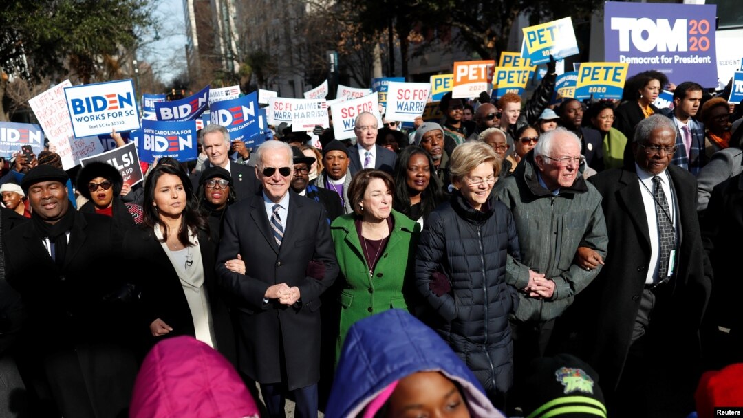 FILE - Democratic presidential rivals Tulsi Gabbard, Joe Biden, Amy Klobuchar, Elizabeth Warren and Bernie Sanders link arms during a Martin Luther King Jr. Day march, Jan. 20, 2020, in Columbia, South Carolina.