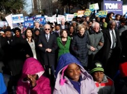 FILE - Democratic presidential rivals Tulsi Gabbard, Joe Biden, Amy Klobuchar, Elizabeth Warren and Bernie Sanders link arms during a Martin Luther King Jr. Day march, Jan. 20, 2020, in Columbia, South Carolina.