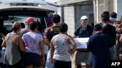 Un hombre lleva el ataúd de uno de los cuatro niños asesinados por hombres armados en Guayaquil, Ecuador, el 12 de diciembre de 2023