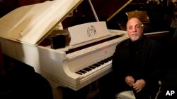 FILE - Billy Joel poses at a piano in New York, Dec. 12, 2011.