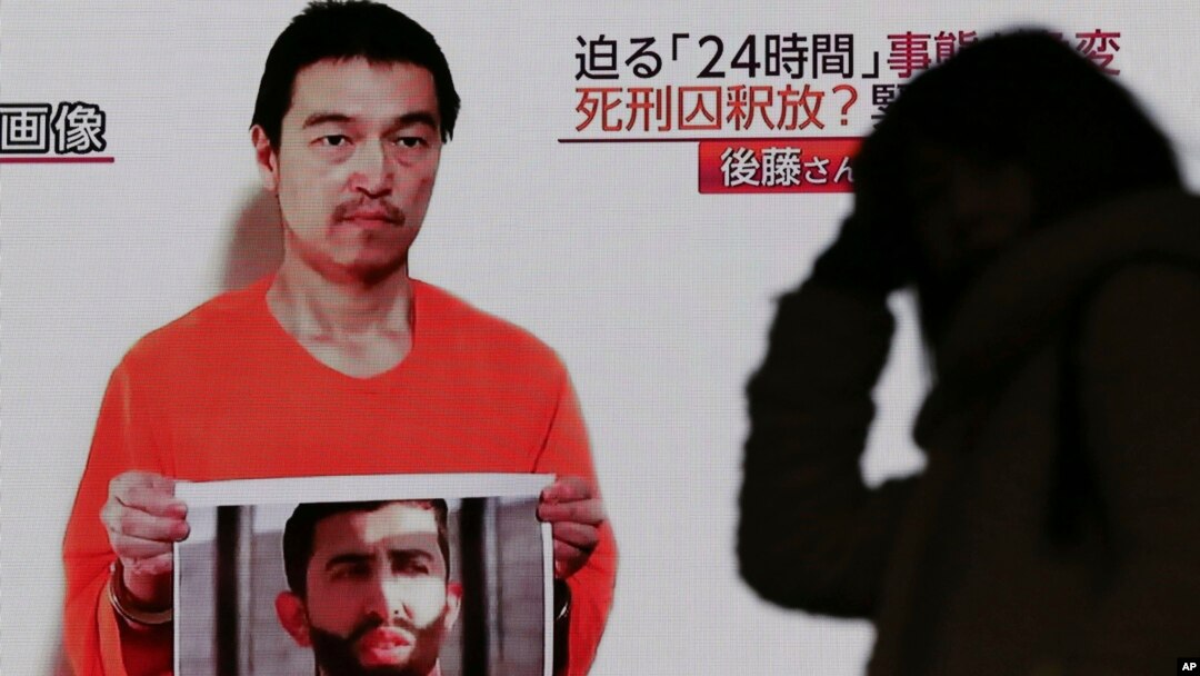 Siaran televisi di Jepang menayangkan sosok Kenji Goto yang disandera ISIS tengah memegang foto pilot Yordania Mu'ath al-Kaseasbeh di Tokyo (28/1).