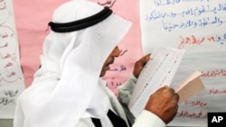 An Egyptian man reads a ballot form preparing to vote at a polling station in El Arish, in the northern part of Egypt's Sinai Peninsula, January 3, 2012.