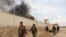 FILE - Smoke rises from a building, where Taliban insurgents hide during a firefight with Afghan security forces, in Helmand province, southwest Afghanistan, March 9, 2016.