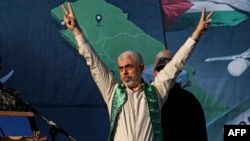 (FILES) Yahya Sinwar, leader of the Palestinian Hamas movement in the Gaza Strip, gestures on stage during a rally in Gaza City on May 24, 2021.