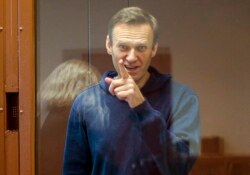 Pemimpin oposisi Rusia Alexey Navalny memberi isyarat selama persidangan atas tuduhan pencemaran nama baik di Pengadilan Distrik Babuskinsky di Moskow, Rusia, dalam foto yang diambil dari rekaman yang disediakan oleh Pengadilan Distrik Babuskinsky, 16 Februari 2021. (Foto: AP)