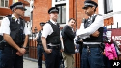 British police guard the Ecuadorian Embassy as protesters in support of Wikileaks founder Julian Assange demonstrate outside the embassy in London, May 20, 2019. 