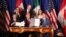 President Donald Trump, center, sits between Canada's Prime Minister Justin Trudeau, right, and Mexico's President Enrique Pena Nieto after they signed a new U.S.-Mexico-Canada Agreement that is replacing the NAFTA trade deal. 