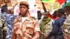 A national guard soldier walks by demonstrators at Bamako airport, Mali, March 29, 2012. (VOA - N. Palus)